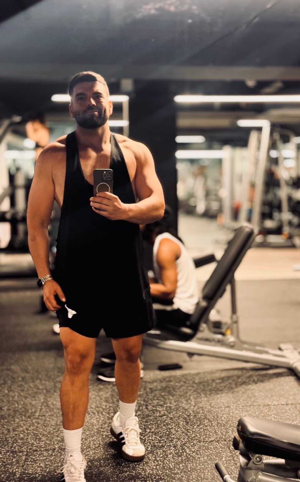 Pablo taking a mirror selfie on the gym floor.