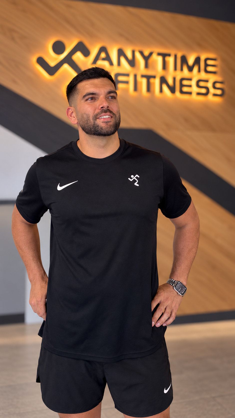 Pablo standing confidently with hands on hips at Anytime Fitness.